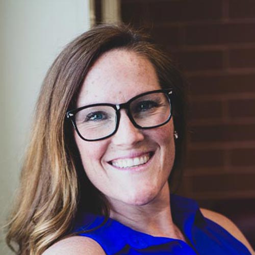 Smiling woman with glasses and brown hair